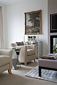 Pair of cream armchairs with mirrored side table in contemporary London home   UK