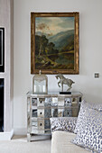 Gilt framed artwork above mirrored side unit in contemporary London living room   UK