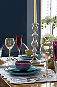 Coloured glassware,  bowl and plate with silver candlestick on dining table in London home,  England,  UK