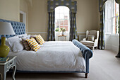 Light blue buttoned double bed and curtain pelmets in Surrey home,  England,  UK