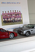 Red and silver collectable cars with photograph of rugby team in Surrey home,  England,  UK
