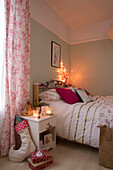 Christmas stocking and gifts with lit candles at bedside in Dronfield home  Derbyshire  England  UK