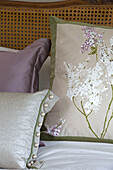 Floral cushion with pearl passementerie on bed in London home   England   UK