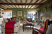 Rote Decke auf Sofa mit eingelegtem Couchtisch im Wohnzimmer in Sussex England UK