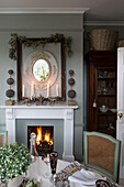 Mirror within picture frame above lit fire in Berkshire home,  England,  UK