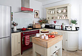Wall mounted shelving with range oven with Christmas cake on butcher's block in Surrey kitchen   England   UK