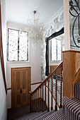 Wooden banister and carpeted staircase with window grille in London townhouse   England   UK
