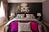 Large black and white print above double bed with antique two-seater sofa London townhouse   England   UK