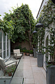 Wooden chairs in private courtyard garden of London home   England   UK
