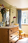 Large vase and mirror on wooden chest of drawers at window of Sandhurst country house  Kent  England  UK