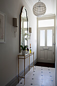 Vintage mirror above metal framed console in entrance hallway of London home, England, UK