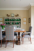 Upholstered chairs with green ceramic plates on dresser in Pewsey dining room Wiltshire England UK