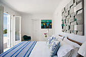 Blue and white striped cover on double bed below mirror in Greek villa Ithaca