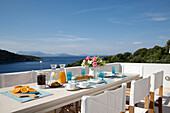 Breakfast table on terrace of Greek villa on island of Ithaca with view of Aegean sea