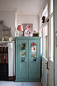Botanical postcards on blue painted storage cupboard in Norfolk home England UK