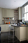 Barhocker aus Metall an der Frühstücksbar in der modernen Küche eines Londoner Stadthauses UK