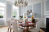 White leather chairs at table in light blue panelled Georgian dining room of London townhouse England UK