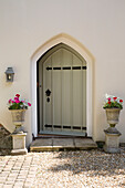 Arched doorway and garden planters at exterior of Dorset home England UK