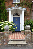 Porchway with blue front door at tiled path at exterior of Arundel home West Sussex England UK