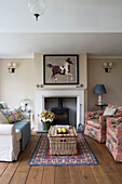 Equestrian artwork above fireplace with picnic basket and seating in Georgian home Berkshire England UK