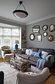 Vintage mirror collection above sofa in UK living room