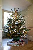 Christmas presents below tree in Sussex home England UK