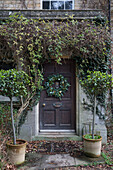 Christmas wreath and fallen leaves at front door of detached Surrey home UK