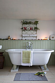 Freistehende Badewanne unter einem Drahtregal mit dem Schriftzug 'NOEL' in einem Haus in Kent, England, UK