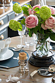 Cut roses and glassware with toothpicks on dining table in London townhouse apartment UK