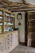 Crockery and glassware on dresser in timber framed Kent farmhouse kitchen UK
