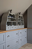Light grey storage shelves and drawers in Grade II listed cottage in Hampshire England UK
