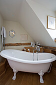 Freestanding roll-top bath in Grade II listed cottage in Hampshire England UK