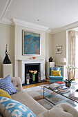 Modern artwork above fireplace in living room of Victorian terraced house London England UK