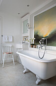 Freestanding roll-top bath with large art canvas in Victorian terraced house London England UK