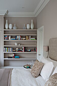 Vases and books on bedroom shelving in Victorian terraced house London England UK