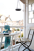 Folding chair at table on balcony of Sussex beach house England UK