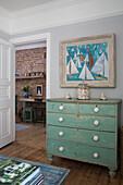 Weathered green chest with nautical artwork at doorway of Sussex beach house England UK