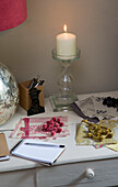 Lit candle and fabric samples on sideboard in Sussex home England UK