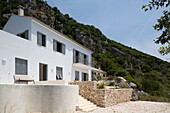 White facade of hilltop villa with steps and patio in Ithaca Greece