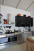 Black wall mounted cupboard above stainless steel fitted kitchen in Ithaca villa Greece