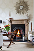 Wooden coffee table in front of lit fire in Worcestershire home England UK