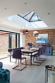 Modern extension with exposed brick wall and skylight pendant shades in Sussex home England UK