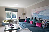 Modern art canvas above corner sofa in living room of Sussex home England UK