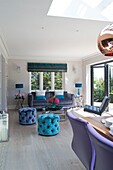 Velvet buttoned footstools in living room extension of Sussex home England UK