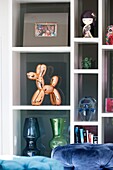 Glass ornaments with copper dog on shelving unit in Sussex living room England UK