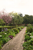 Kiesweg und Blumenbeete im Garten eines unter Denkmalschutz stehenden georgianischen Landhauses (Grade II) Shropshire, England, UK