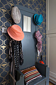 Hatstand with scarves and bee wallpaper in Sussex hallway England UK