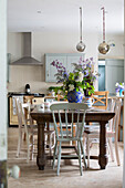 Cut flowers on antique wooden table with painted chairs in Kelso kitchen Scotland UK