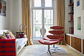 Pop-Art-Kissen mit rotem Sessel und Fußhocker in einem Londoner Stadthaus England UK