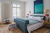 Hues of teal with modern artwork above double bed in London townhouse England UK